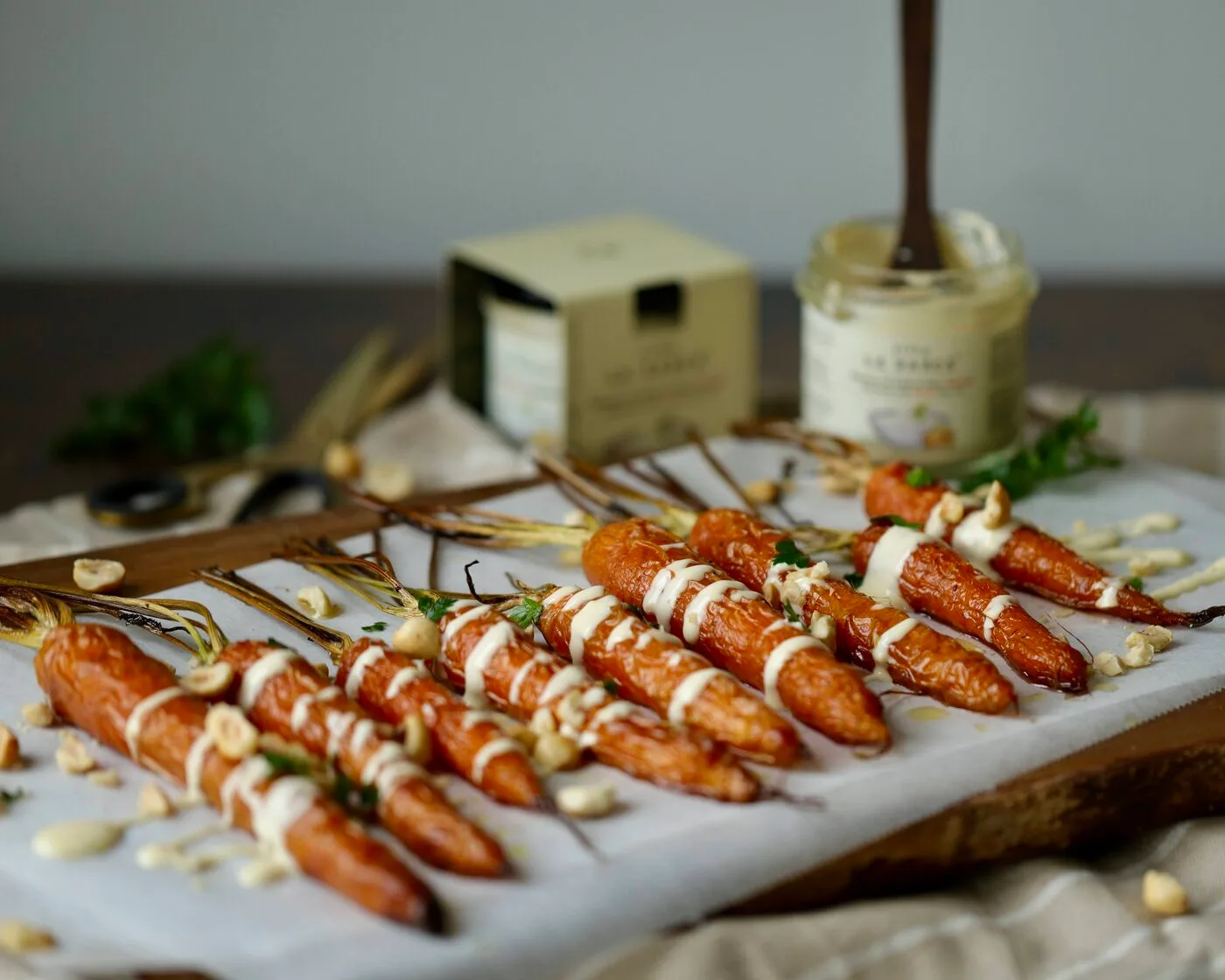 Geroosterde wortels met een romige saus en hazelnoten op een snijplank