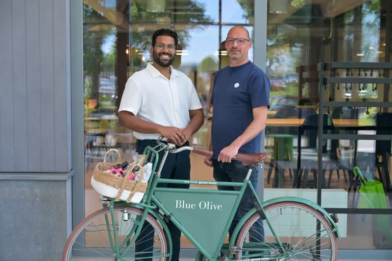 Rachad en Youri van Blue Olive met de Blue Olive-fiets voor hun kantoor
